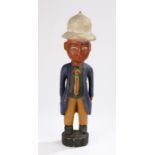 West African carved and painted figure, with a pith helmet and suited figure, 55cm high
