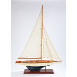 Model of a pond boat, fully rigged with a white and blue hull, raised on a stand, 62cm long