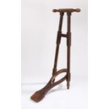 Victorian boot jack, with turned handle above the folding boot jack