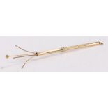 9 carat gold swizzle stick, the slender stock with a sliding collar revealing the swizzle end, 8.5cm