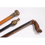 Walking sticks, to include a Chinese example with dragons to the capped top, another with a gilt