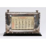 George V silver desk calendar, the internal calendar framed with a silver mount, 20cm diameter