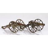Two Victorian miniature cannons, with tapered barrels and metal carriages, 18cm long, (2)