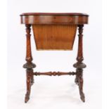 Victorian walnut sewing table, the shaped hinged top above a basket, the basket is flanked by ring