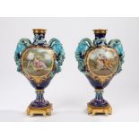 Pair of 19th Century Sevres porcelain vases, the ormolu caps above ram form handles, the body with