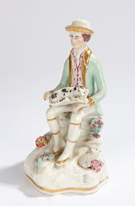 19th Century Staffordshire pottery figure, of a seated wearing a hat and a spotted dog to his lap,