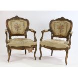 Pair of Louis XV style armchairs, with a shell carved scroll top rail above a floral tapestry back
