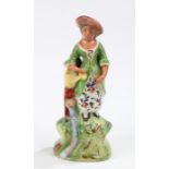 Early 19th Century Walton pearlware figure, of a standing lady with a watering can and a grotesque