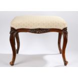 19th Century walnut stool, the serpentine stuff over top above foliate carved arched edge on
