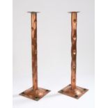 Pair of Arts & Crafts copper candlesticks, with shaped tall columns above the square section base