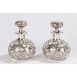 Pair of Art Nouveau white metal overlaid glass bottles, the overlay in foliate scrolling swags, 11cm