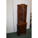 Walnut veneered standing corner cupboard, with astragal glazed door above a simulated panelled