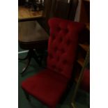 Victorian prie-dieu chair, upholstered in a red fabric with button back, on turned legs and castors