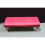 Upholstered footstool, on turned mahogany legs and brass castors, 94cm wide