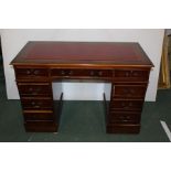 Walnut veneered twin pedestal desk, the red leatherette inset top above three frieze drawers and