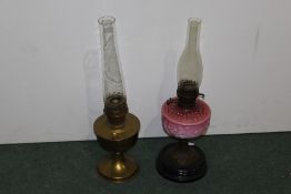 Two oil lamps, one with pink glass the other in gilt brass, (2)