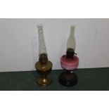 Two oil lamps, one with pink glass the other in gilt brass, (2)