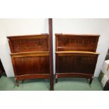 Pair of Edwardian single beds, with scroll inlaid headboards and curved footboards, together with