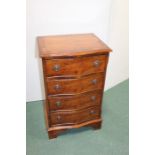 Walnut veneered serpentine front chest of four long drawers, raised on bracket feet, 46cm wide