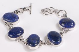 Silver bracelet set with five oval lapis lazuli panels