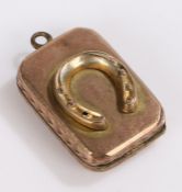 Gold coloured metal locket, with horseshoe to one side and vacant cartouche to the other, 5.6g