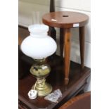 Milking stool with circular seat and turned legs, brass oil lamp now converted to an electric