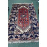 Middle Eastern Carpet, the red ground with multiple borders and tasselled ends,