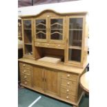 Pine dresser, the arched pediment above four glazed cupboard doors, three drawers and a central open