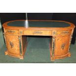 Neoclassical style walnut veneered desk, the oval top with green leatherette inset top and three