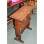 Oak Arts and Crafts style two tier table, on pierced silhouette end supports united by a shaped