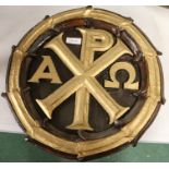 Carved oak Chi Rho panel with gilt letters, 37cm diameter