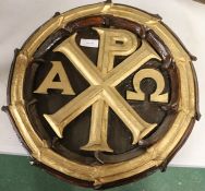 Carved oak Chi Rho panel with gilt letters, 37cm diameter