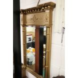 Regency style gilt wall mirror, with orb form pediment above a bevelled mirror plate flanked by