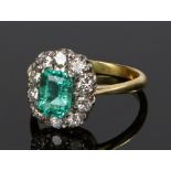 18 carat gold emerald and diamond set ring, the central emerald at an estimated 1.03 carat and a