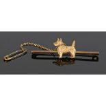 9 carat gold bar brooch, with central depiction of a Scottie dog, with attached security chain,