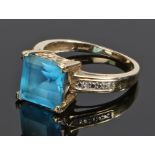 9 carat gold blue topaz and diamond ring, the square topaz flanked by a small diamond to each