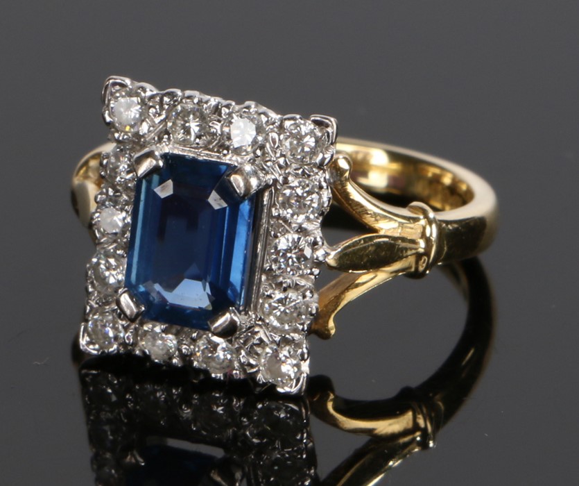 18 carat gold sapphire and diamond set ring, the central baguette sapphire with a diamond