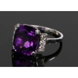 Amethyst and diamond set ring, the central amethyst at 6.60 carats flanked by diamonds on a white