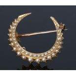 19th Century yellow metal and pearl set crescent brooch, set with two rows of pearls, 32mm high