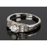 18 carat gold and diamond ring, the central diamond at approximately .8 carat flanked by stepped