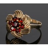 9 carat gold garnet set ring, the head with seven garnets forming a flower head, ring size M 1/2