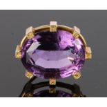 Amethyst brooch, with a gold surround and leaf terminals, the amethyst at an estimated 22 carats,