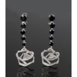 Gavello pair of earrings, with black stones above diamonds set to the stylised drops, 80mm long