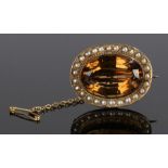 Citrine and pearl brooch, the central oval citrine with a pearl surround, 31mm diameter
