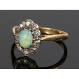 18 carat gold opal and diamond ring, the central oval opal surrounded by a band of diamonds, ring