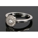 Platinum and diamond set ring, the circular head set with a central diamond and diamond surround,