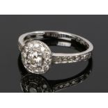 Platinum and diamond set ring, with a central diamond and diamond surround trailing down the