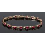 9 carat gold ruby set bracelet, the oval rubies interspersed by pierced links, 5.7g
