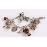 Silver charm bracelet, with twelve charms and heart shaped clasp, 38.6g