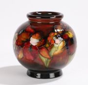 Moorcroft pottery vase, the squat vase with red ground and a foliate leaf design, 13cm high